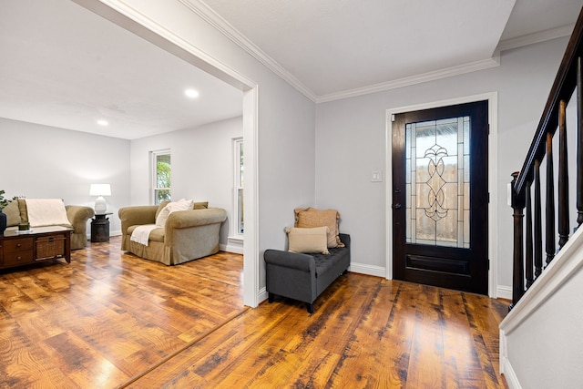 entryway with recessed lighting, wood finished floors, baseboards, stairs, and ornamental molding