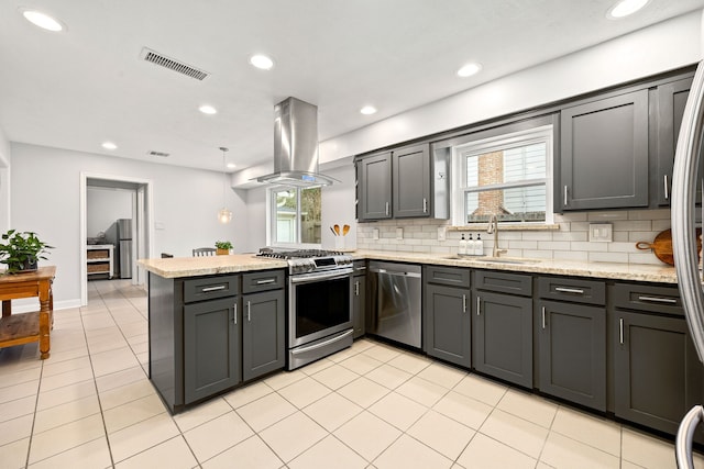 kitchen featuring stainless steel appliances, a peninsula, a sink, visible vents, and island exhaust hood