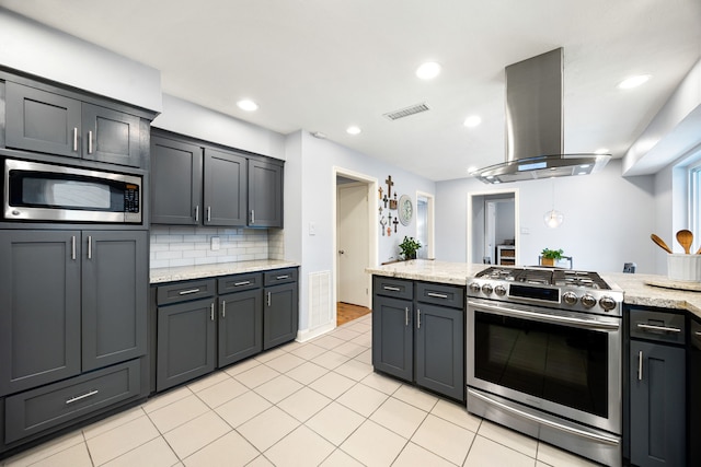 kitchen with light tile patterned floors, island range hood, decorative backsplash, stainless steel appliances, and recessed lighting