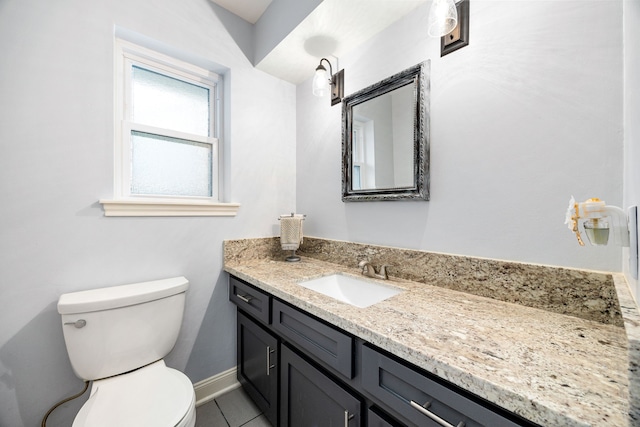 half bath featuring tile patterned flooring, vanity, toilet, and baseboards