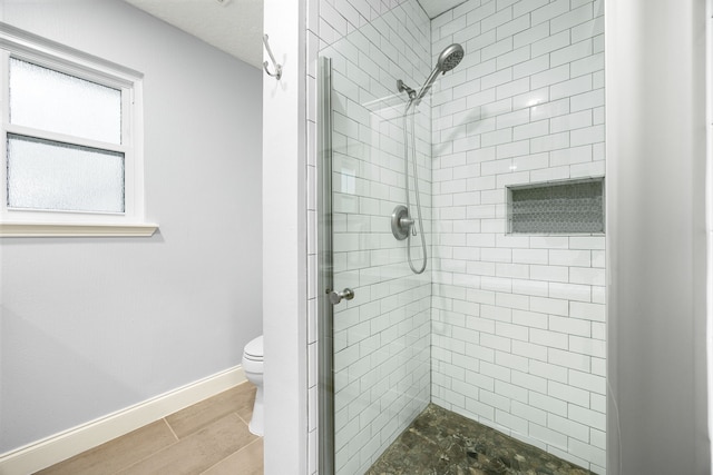 full bath with a stall shower, baseboards, and toilet