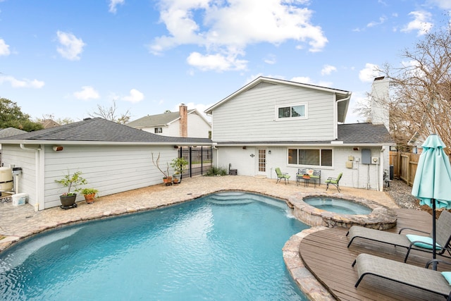 outdoor pool featuring a fenced backyard, a patio, and an in ground hot tub