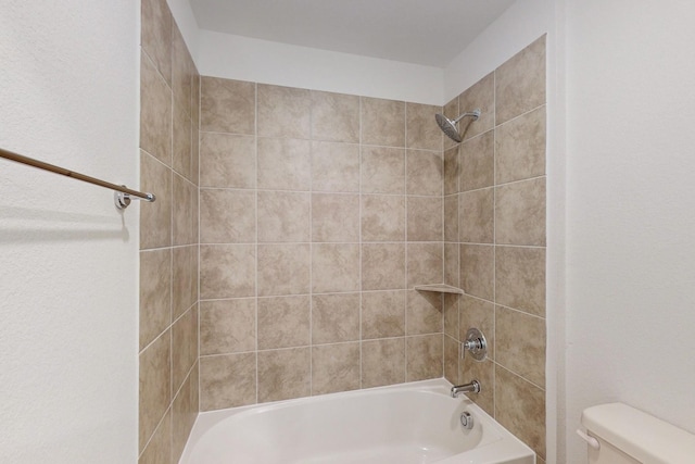 bathroom featuring tiled shower / bath and toilet