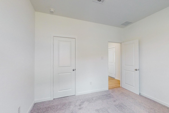 unfurnished bedroom with light colored carpet