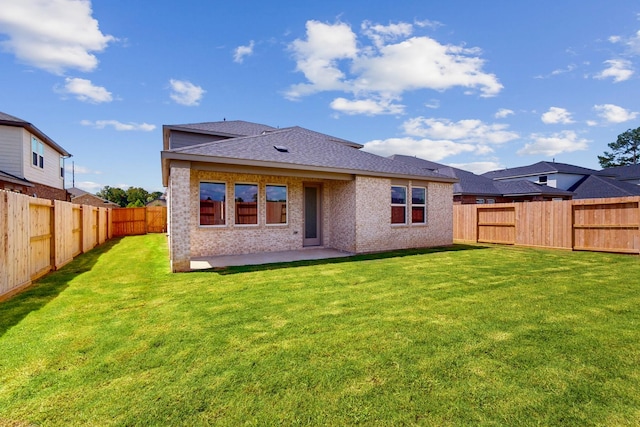 rear view of property with a patio and a lawn