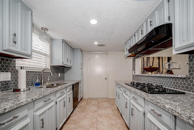 kitchen featuring visible vents, a sink, light stone countertops, under cabinet range hood, and black appliances