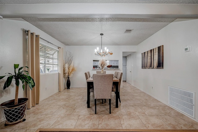 dining room featuring visible vents, a chandelier, and a textured ceiling