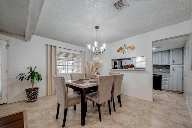 dining room featuring an inviting chandelier, baseboards, visible vents, and a textured ceiling