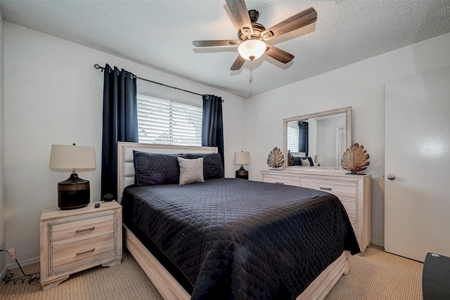 bedroom featuring light carpet, a ceiling fan, and a textured ceiling