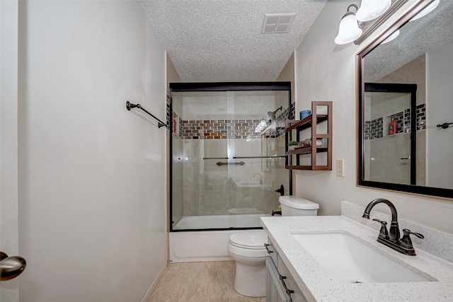 full bathroom with shower / bath combination with glass door, visible vents, toilet, a textured ceiling, and vanity