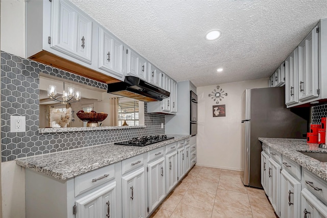 kitchen featuring tasteful backsplash, white cabinetry, under cabinet range hood, and black appliances