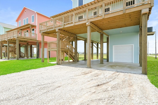 view of front facade featuring a wooden deck, a garage, a front yard, and a carport