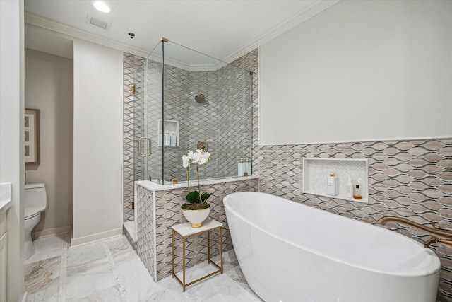 bathroom featuring marble finish floor, crown molding, a shower stall, a freestanding tub, and baseboards