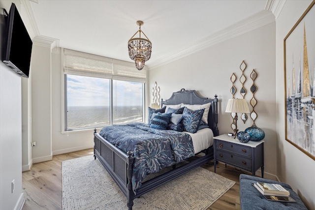 bedroom with light wood-style floors, baseboards, a chandelier, and crown molding