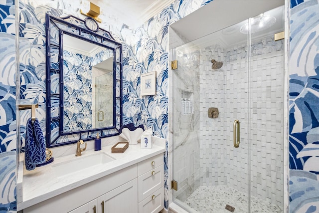 full bathroom with ornamental molding, a stall shower, vanity, and wallpapered walls