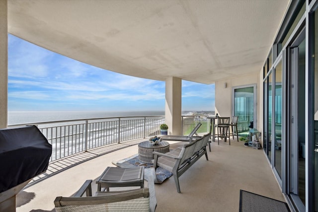 view of patio featuring area for grilling, a water view, and a balcony