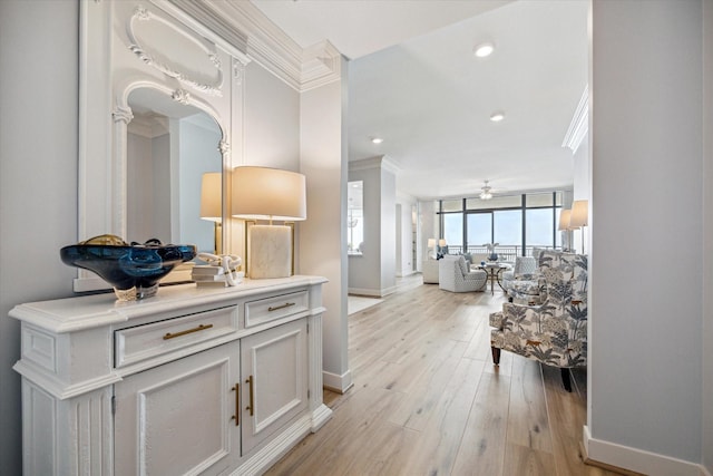 hall featuring baseboards, recessed lighting, light wood-style flooring, and crown molding