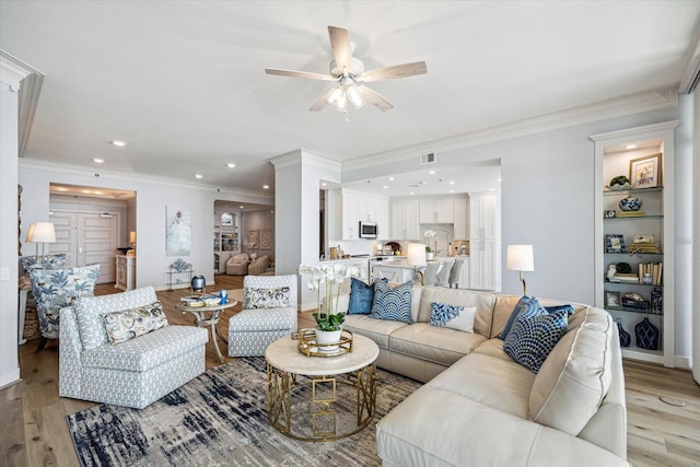 living room with ceiling fan, recessed lighting, visible vents, ornamental molding, and light wood finished floors