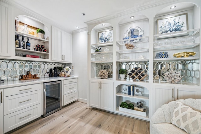 bar with a dry bar, light wood finished floors, decorative backsplash, wine cooler, and crown molding