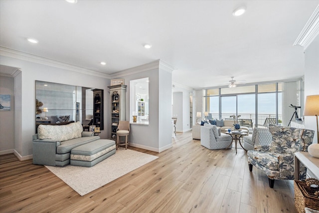 living room with baseboards, recessed lighting, light wood-style flooring, and crown molding