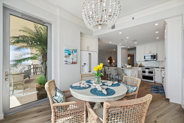 dining room with light wood finished floors, recessed lighting, visible vents, an inviting chandelier, and ornamental molding