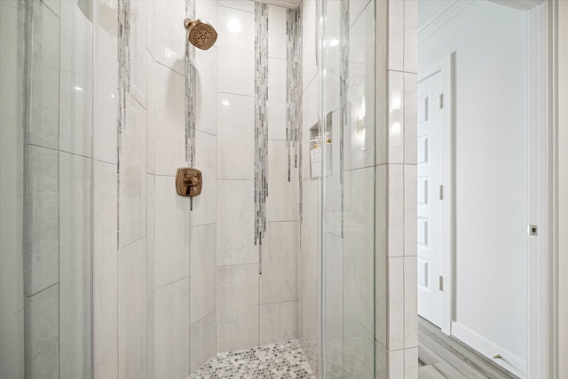 full bath with crown molding, a tile shower, and wood finished floors