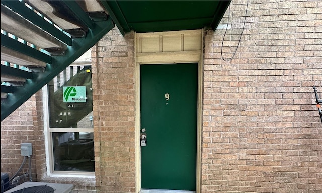 entrance to property featuring brick siding