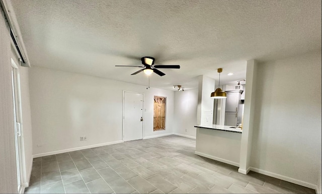 unfurnished living room featuring a textured ceiling, baseboards, and ceiling fan