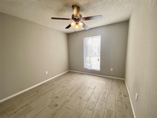 spare room featuring a ceiling fan, wood finished floors, baseboards, and a textured ceiling