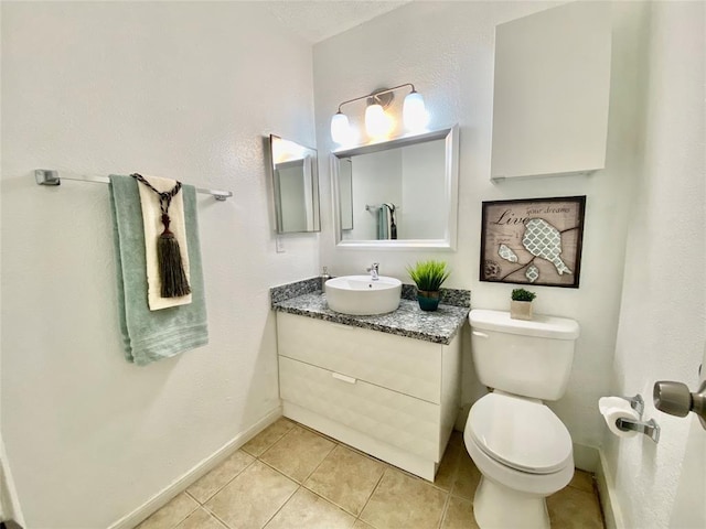 bathroom featuring tile patterned floors, baseboards, toilet, and vanity