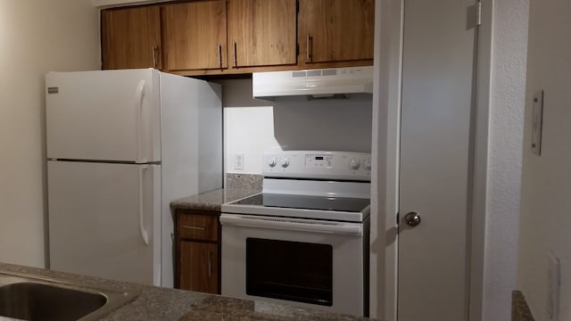 1516 Bay Area Blvd Unit S6, B9, E7, S11, K15, K3, Houston, TX 77058 - kitchen with stone countertops, brown cabinetry, under cabinet range hood, and white appliances