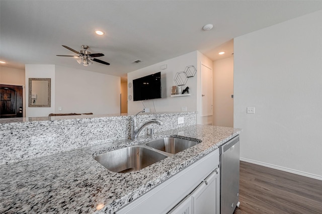 kitchen featuring dark hardwood / wood-style floors, sink, white cabinets, stainless steel dishwasher, and light stone countertops