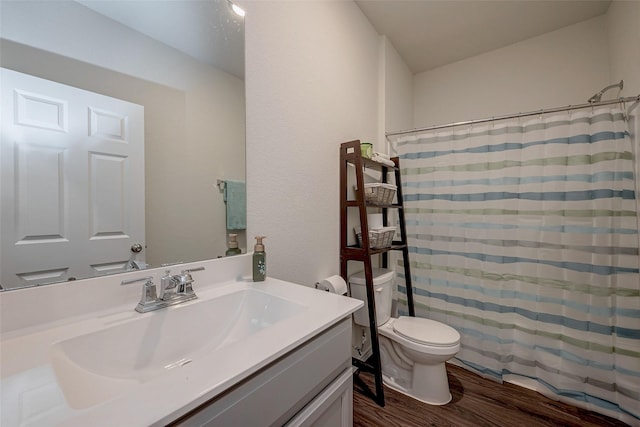 bathroom featuring wood-type flooring, toilet, vanity, and a shower with shower curtain