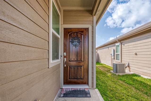 entrance to property with cooling unit and a yard