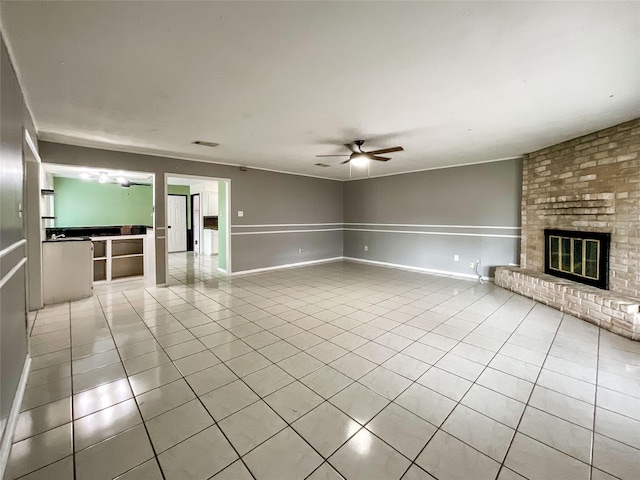 unfurnished living room featuring ceiling fan, light tile patterned floors, and a fireplace