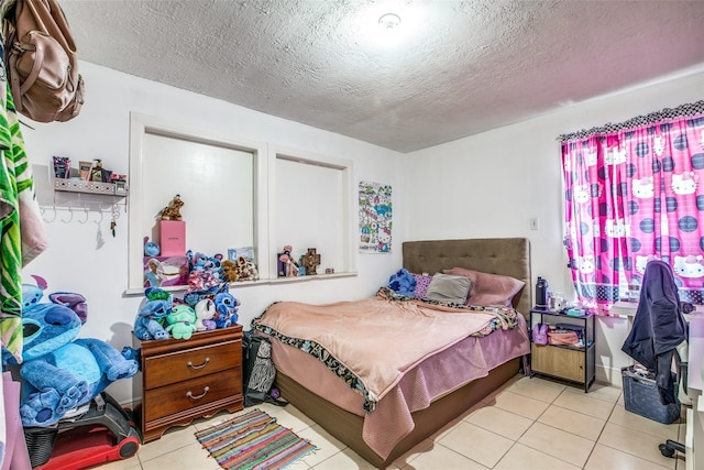 tiled bedroom featuring a textured ceiling