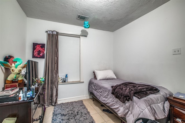 tiled bedroom featuring a textured ceiling