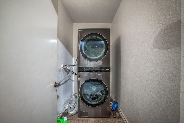 laundry room with stacked washer and dryer and a textured ceiling