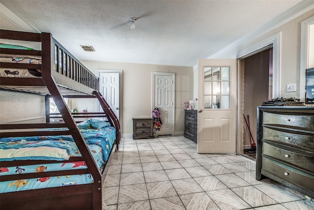 bedroom with light tile patterned flooring and a textured ceiling