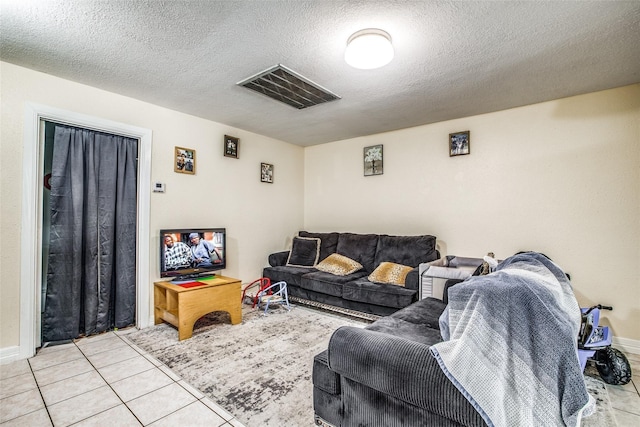 living room featuring a textured ceiling and light tile patterned floors