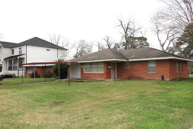 view of front of property featuring a front yard, a carport, and brick siding