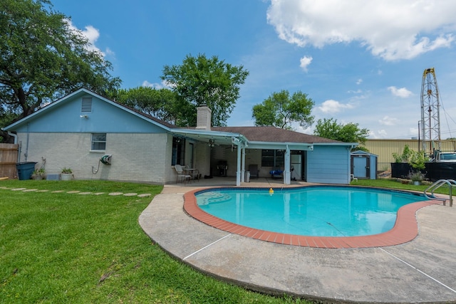 view of swimming pool with a lawn, an outdoor structure, and a patio