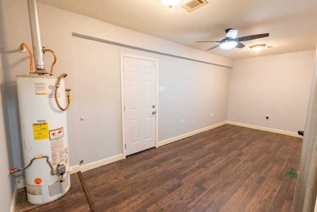 basement with gas water heater, dark wood-type flooring, and ceiling fan