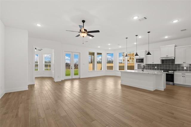 32626 Fly Fish Way, Fulshear, TX 77441 - unfurnished living room with ceiling fan, recessed lighting, a sink, light wood-type flooring, and baseboards