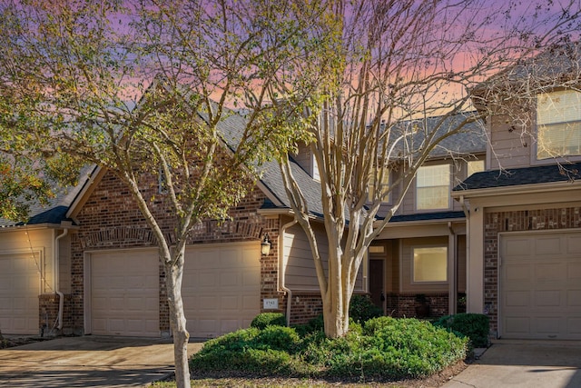 view of front of house featuring a garage, brick siding, and concrete driveway