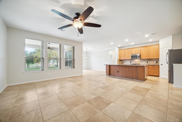 kitchen featuring visible vents, light tile patterned flooring, stainless steel appliances, open floor plan, and backsplash