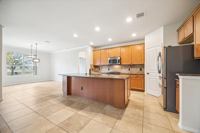 kitchen featuring light tile patterned flooring, sink, tasteful backsplash, stainless steel appliances, and a kitchen island with sink