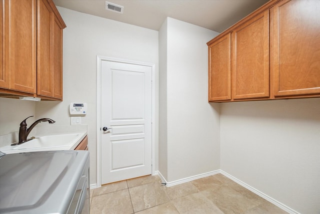 washroom featuring cabinets, sink, and washer / clothes dryer