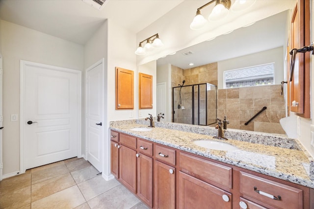 bathroom with double vanity, visible vents, a stall shower, and a sink