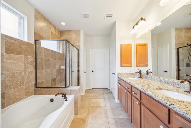 full bath with visible vents, a stall shower, a garden tub, and a sink